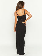Frau in elegantem, schwarzem Maxikleid mit Spaghettiträgern, Rückansicht. Perfekt für Abendmode, Sommerkleid, stilvolle Damenbekleidung.