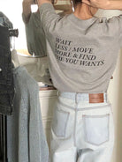 Graues T-Shirt mit inspirierendem Zitat, kombiniert mit hellblauen Jeans. Perfekt für lässige Mode und Streetwear-Trends.