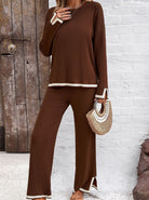 Damen-Outfit in Braun, bestehend aus langärmligem Oberteil und weiter Hose, kombiniert mit einer stilvollen Strohtasche. Perfekt für den Herbst.