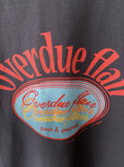 Graues T-Shirt mit rotem und blauem "Overdue Flair"-Print, modisches Design, lässiger Stil, ideal für Streetwear und trendige Outfits.