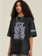 Schwarzes Oversize-T-Shirt mit auffälligem "FLY NOW WIN NOW"-Print, ideal für Streetwear-Looks. Perfekt für trendbewusste Modefans.