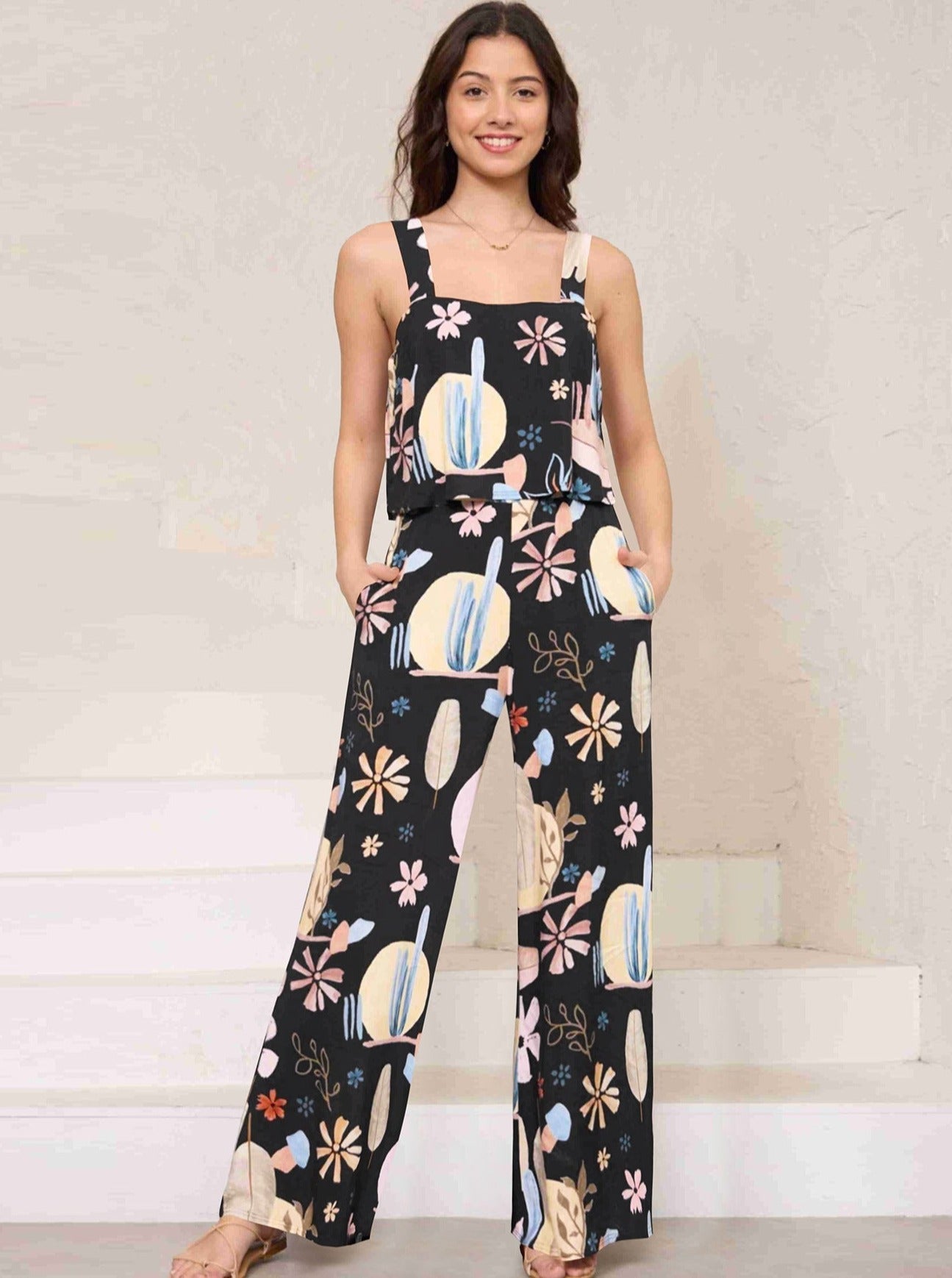 Frau in schwarzem, geblümtem Jumpsuit, lässig und modisch. Perfekt für Sommermode, Freizeitkleidung, Damenbekleidung, trendige Outfits.
