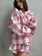 Frau in kariertem Pyjama-Set aus weichem Stoff, ideal für gemütliche Nächte. Modisches Design, bequeme Passform, perfekte Nachtwäsche für Damen.