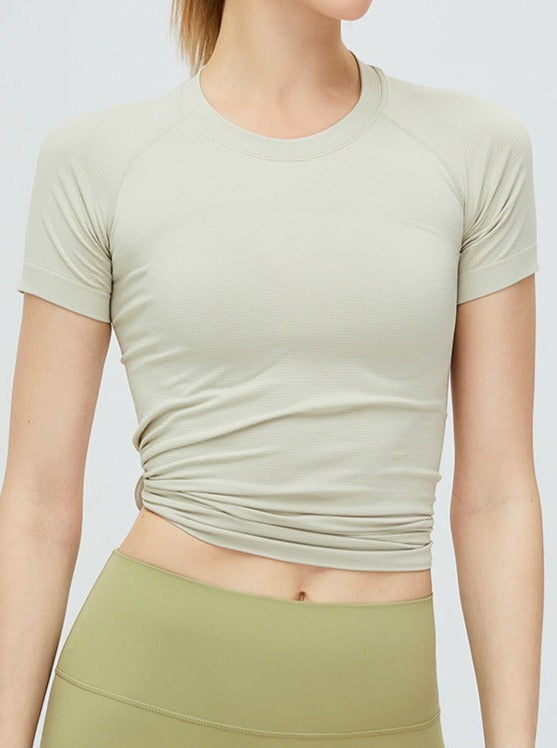 Damen-Sportshirt in Beige, kurzärmelig, atmungsaktiv, ideal für Fitness und Yoga. Hochwertige Materialien, figurbetontes Design.