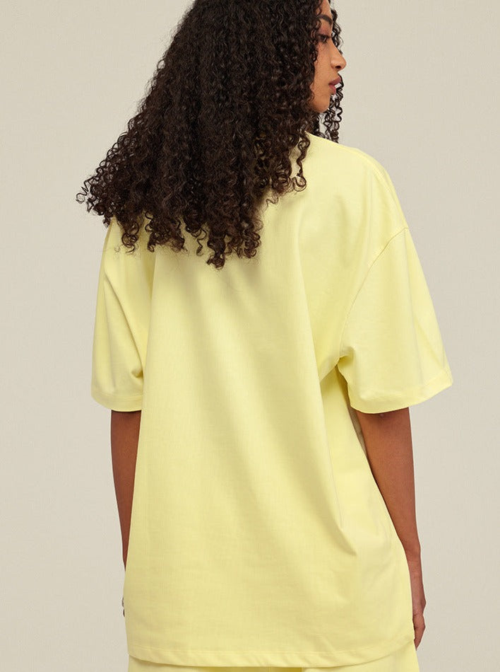 Gelbes Oversize-T-Shirt aus Baumwolle, Damenmode, Rückansicht. Perfekt für lässige Outfits, bequem und stilvoll. Ideal für Sommertrends.