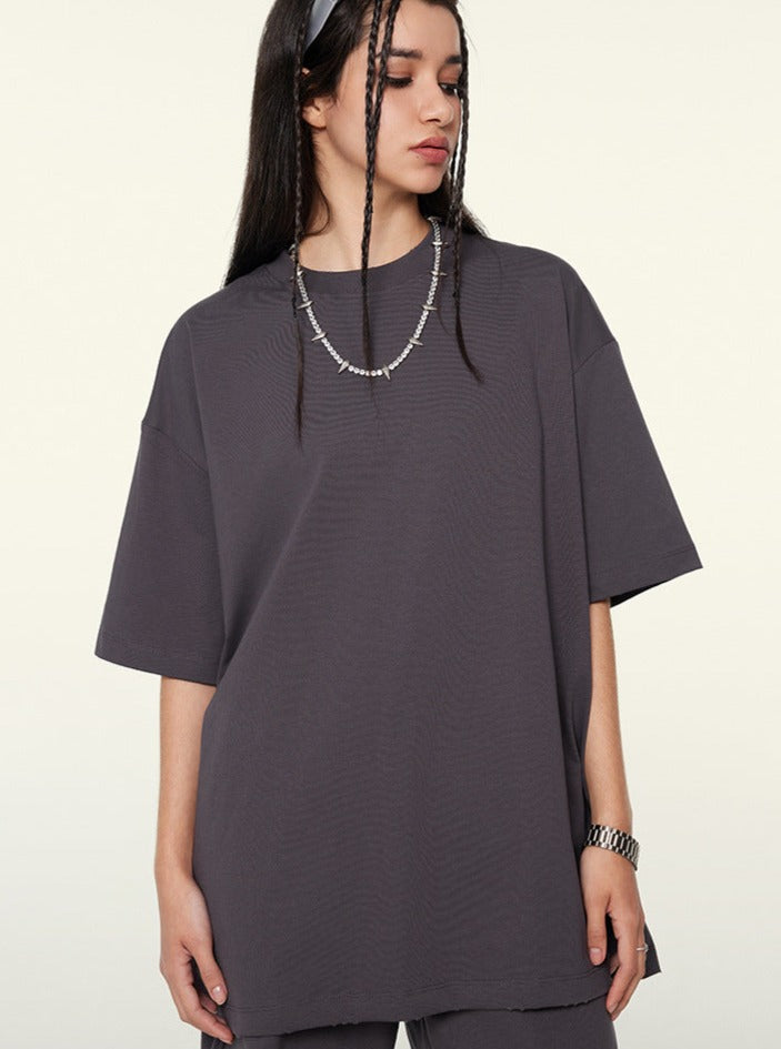 Graues Oversize-T-Shirt für Damen, lässiger Stil, aus Baumwolle, ideal für Streetwear und Freizeitmode. Perfekt kombinierbar mit Accessoires.