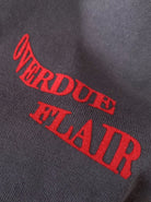 Graues Sweatshirt mit rotem Schriftzug "OVERDUE FLAIR". Modetrend, Streetwear, bequeme Kleidung, stilvolles Design, Baumwollstoff.