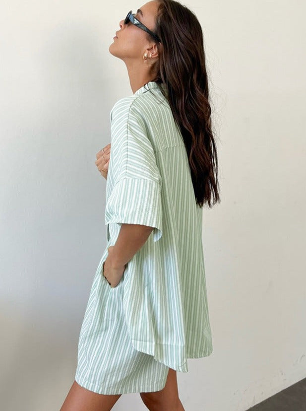 Frau in gestreiftem, mintgrünem Hemdkleid, seitlich posierend. Sommermode, lässiger Stil, trendiges Outfit, Damenbekleidung, modische Streifen.