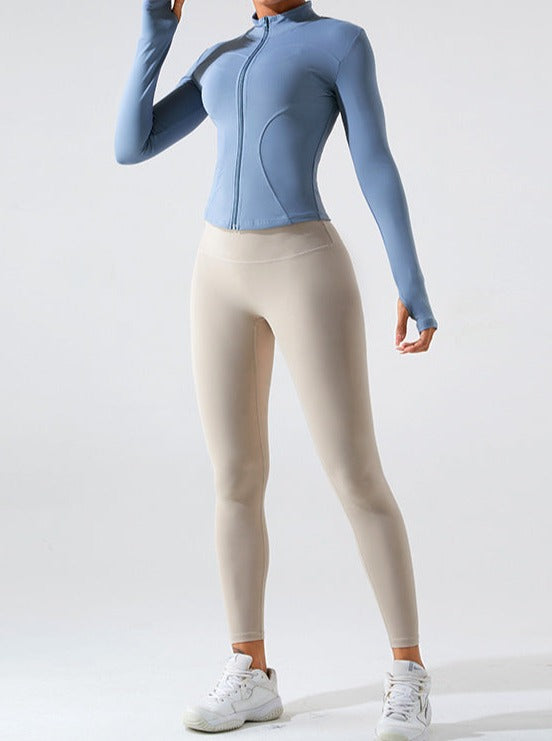 Damen-Sportbekleidung: Figurbetontes, langärmeliges, blaues Oberteil und beige Leggings. Ideal für Fitness, Yoga und Freizeit.