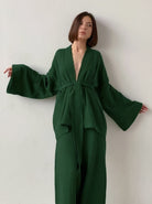 Frau in elegantem, grünem Kimono mit weitem Schnitt, minimalistisches Design, modischer Look, ideal für stilvolle Anlässe und moderne Outfits.
