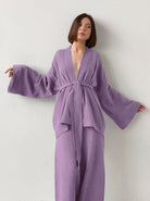 Frau in lila Kimono-Set mit weitem Schnitt, ideal für modische Freizeitkleidung. Trendige Damenmode, bequem und stilvoll.