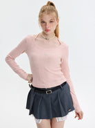 Junge Frau in rosa Strickpullover und grauem Faltenrock. Modetrend, Damenbekleidung, stilvolle Outfits, Herbstmode, lässiger Look.