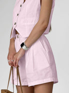 Damen Sommeroutfit in Rosa: ärmelloses Oberteil mit Knopfleiste und passender Shorts. Perfekt für stilvolle, leichte Sommermode.