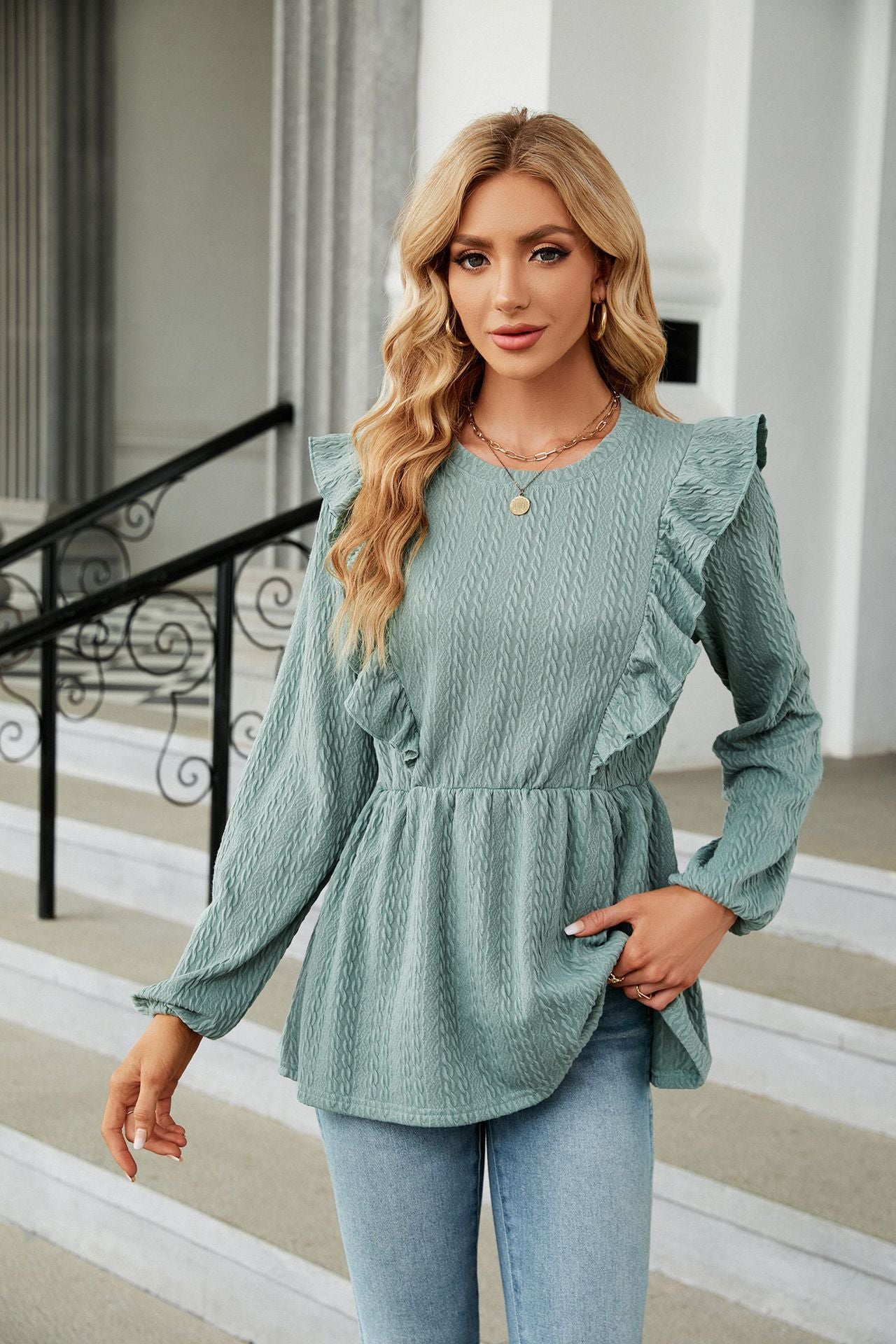 Dame in eleganter, hellblauer Rüschenbluse und Jeans. Modetrend, stilvolle Damenmode, Freizeitlook, moderne Kleidung, modische Outfits.