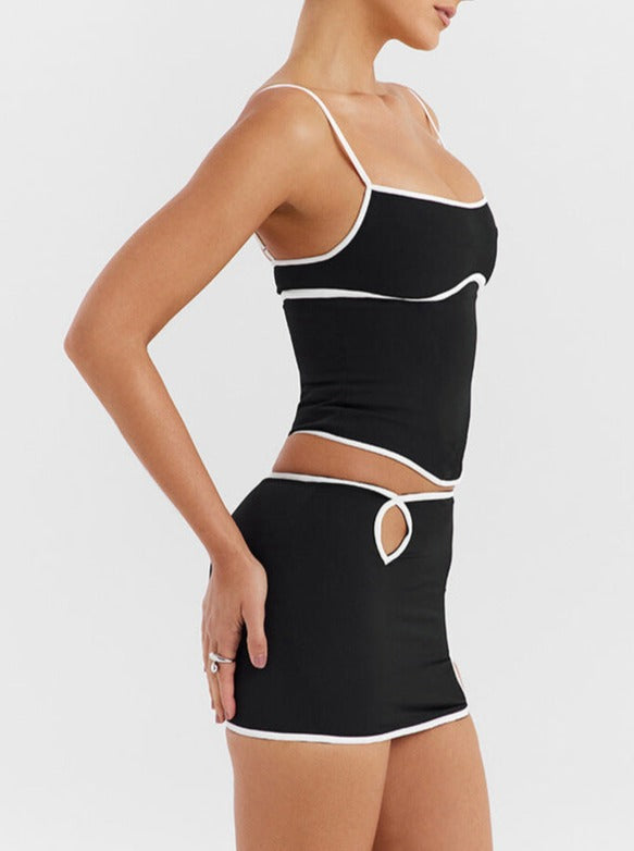 Schwarzes Damen-Zweiteiler-Set mit weißem Rand, bestehend aus Crop-Top und Minirock. Modische Sommerkleidung, ideal für trendige Outfits.