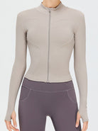 Damen-Sportjacke in Beige mit Reißverschluss, langärmlig, figurbetont, ideal für Fitness und Yoga. Hochwertige Materialien, modisches Design.