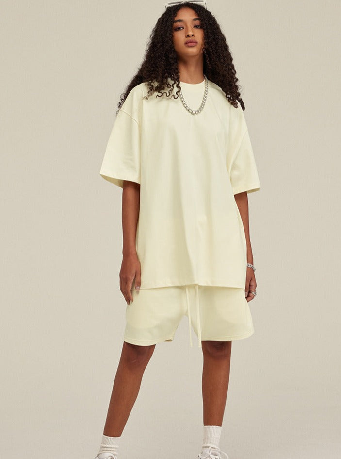 Frau in cremefarbenem Oversize-T-Shirt und Shorts, modisch, lässig, Streetwear, Sommeroutfit, trendige Damenmode, bequeme Kleidung.