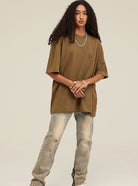 Braunes Oversize-T-Shirt, lässiger Look, kombiniert mit hellen Jeans. Perfekt für Streetwear, modische Freizeitkleidung, Unisex-Style.