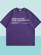 Lila T-Shirt mit weißem Aufdruck "DREAMAGE THE MIDNIGHTS", lässiger Stil, Unisex, ideal für Streetwear und Freizeitmode.