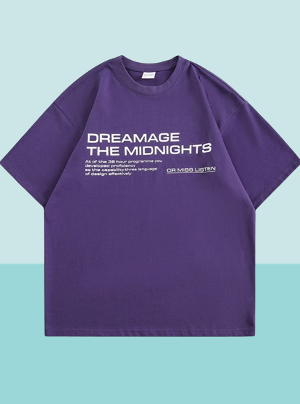 Lila T-Shirt mit weißem Aufdruck "DREAMAGE THE MIDNIGHTS", lässiger Stil, Unisex, ideal für Streetwear und Freizeitmode.