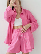Frau in pinkem Freizeit-Set aus Hemd und Shorts, kombiniert mit weißem Top. Modetrend, lässiger Stil, Sommeroutfit, Damenbekleidung.