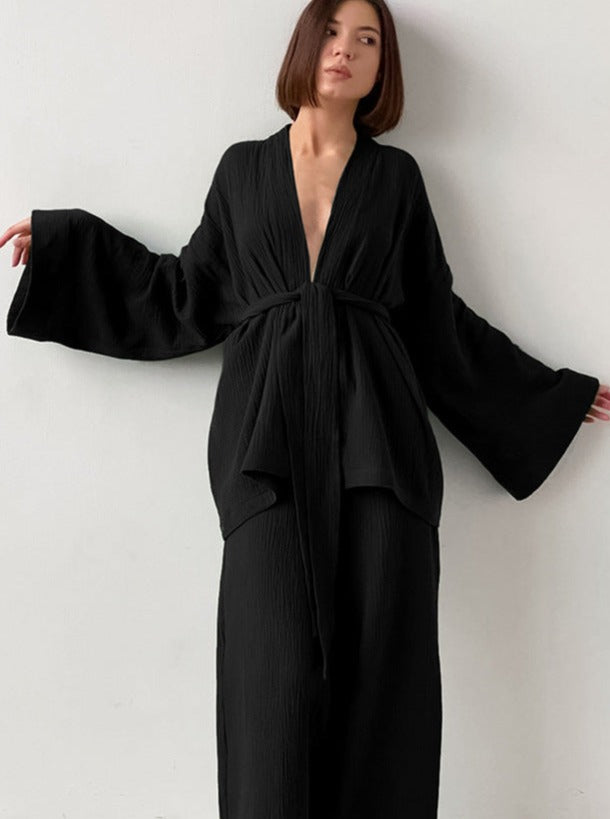 Elegantes schwarzes Kimono-Kleid mit weitem Schnitt und Gürtel, ideal für stilvolle Anlässe. Perfekt für Modebewusste, die Minimalismus schätzen.