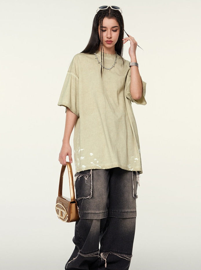 Frau in oversized T-Shirt und Baggy-Jeans, trägt eine Sonnenbrille auf dem Kopf und hält eine braune Handtasche. Streetwear, lässiger Stil, Mode.