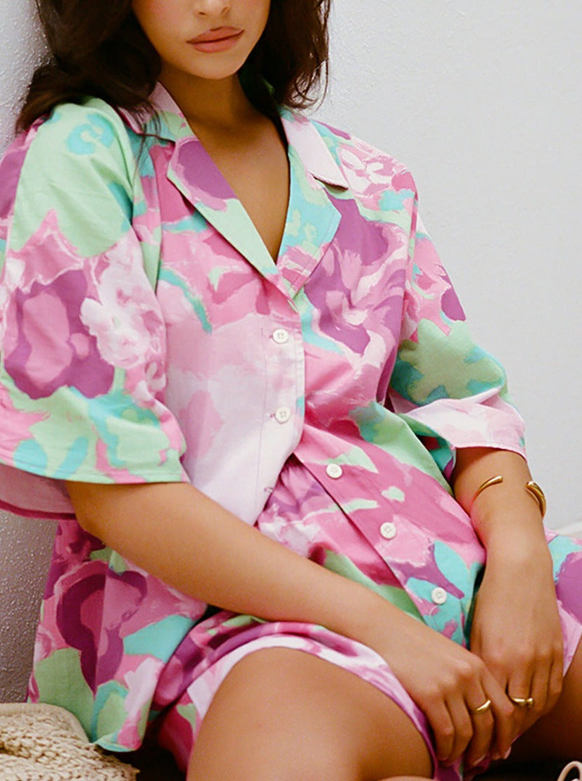 Frau in farbenfrohem, geblümtem Pyjama-Set aus Baumwolle, ideal für bequeme Nachtwäsche. Modetrend, Damenmode, Schlafanzug, Blumenmuster.