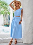 Elegantes blaues Sommerkleid für Damen, ärmellos mit Schleifendetail, ideal für Strandmode. Perfekt für stilvolle Sommeroutfits und Urlaubslooks.