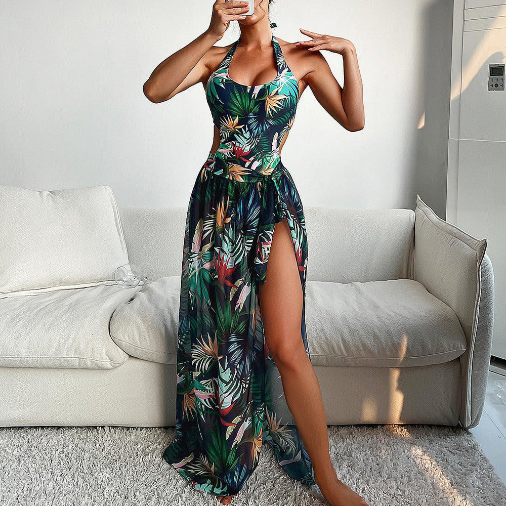 Frau in tropischem Maxikleid mit Blumenmuster, seitlicher Schlitz, ärmellos, Sommermode, elegantes Design, ideal für Strand und Urlaub.