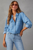 Frau in lässigem Jeanshemd und Jeans, modisch mit Sonnenbrille und Schmuck. Perfekter Look für Freizeit und Streetstyle. Trendige Damenmode.