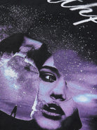 Schwarzes T-Shirt mit lila Grafikdruck, zeigt ein abstraktes Gesicht und kosmische Elemente. Trendige Streetwear, Unisex-Mode, urbaner Stil.