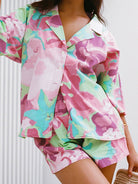 Farbintensiver Pyjama-Set mit floralem Muster, bestehend aus Hemd und Shorts. Perfekt für bequeme Nächte und stilvolle Loungewear.