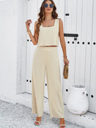 Elegantes Damen-Outfit: Beiges, ärmelloses Top und weite Hose, ideal für Sommermode. Perfekt für stilvolle Freizeit- und Strandlooks.