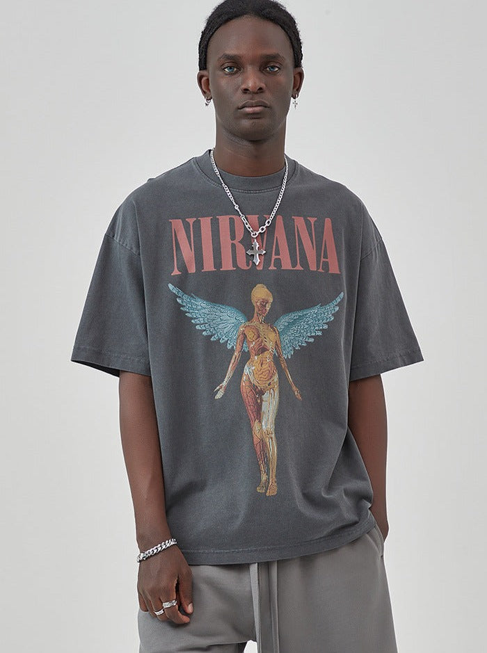 Schwarzes Nirvana-T-Shirt mit anatomischem Engel-Design, getragen von einem Mann. Perfekt für Grunge-Mode, Streetwear und Musikfans.