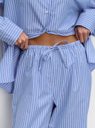 Gestreifte Pyjama-Hose in Blau-Weiß, bequem und stilvoll, ideal für entspannte Nächte. Perfekte Nachtwäsche für Damen, modisch und gemütlich.
