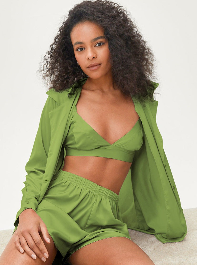 Frau in grüner Freizeitkleidung: Set aus Hemd, Bralette und Shorts. Modetrend, Sommeroutfit, bequeme Damenmode, stilvoll und modern.