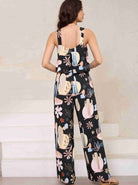 Frau in schwarzem Jumpsuit mit buntem Kaktus- und Blumenmuster, ärmellos, modisch, lässig, ideal für Sommermode und Freizeitkleidung.