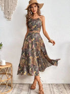 Damen-Sommerkleid mit tropischem Muster, ärmellos, knielang, ideal für Strandmode. Perfekt kombiniert mit Strohhut und Sandalen.