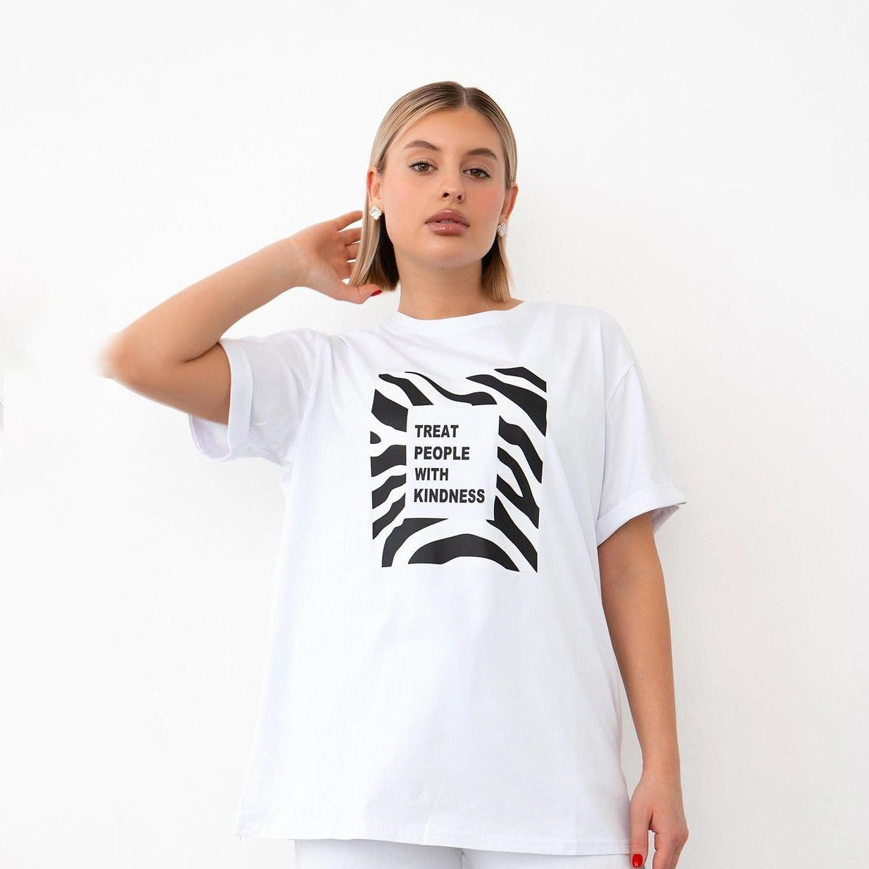 Weißes T-Shirt mit schwarzem Zebra-Muster und "Treat People With Kindness"-Aufdruck, ideal für modische Streetwear und lässige Outfits.
