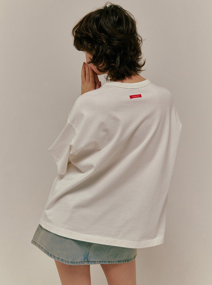 Person in weißem Oversize-T-Shirt und Jeansrock, Rückenansicht. Modetrend, lässiger Stil, minimalistisch, urban, Streetwear, Damenmode.