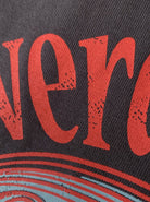 Nahaufnahme eines Vintage-Posters mit rotem, abgenutztem Schriftzug auf schwarzem Hintergrund. Retro-Design, Textur, Wanddekoration.