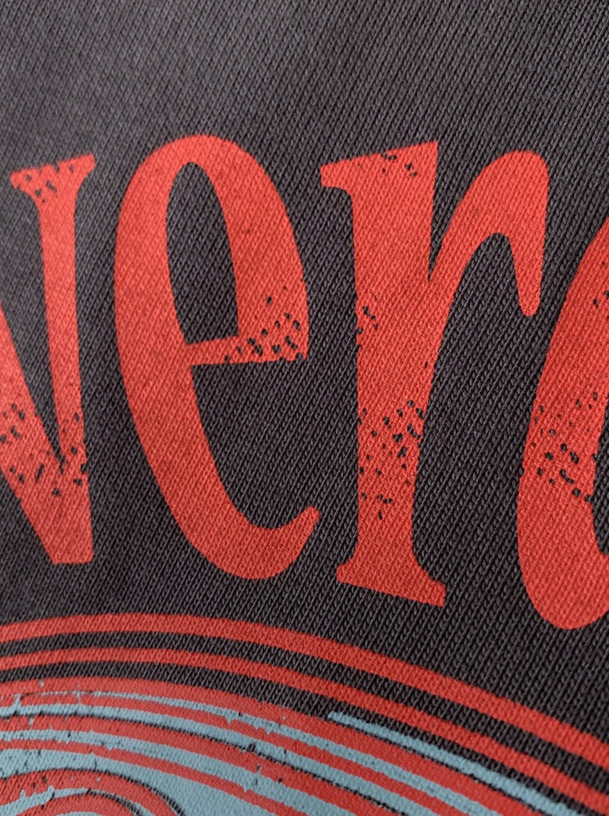 Nahaufnahme eines Vintage-Posters mit rotem, abgenutztem Schriftzug auf schwarzem Hintergrund. Retro-Design, Textur, Wanddekoration.