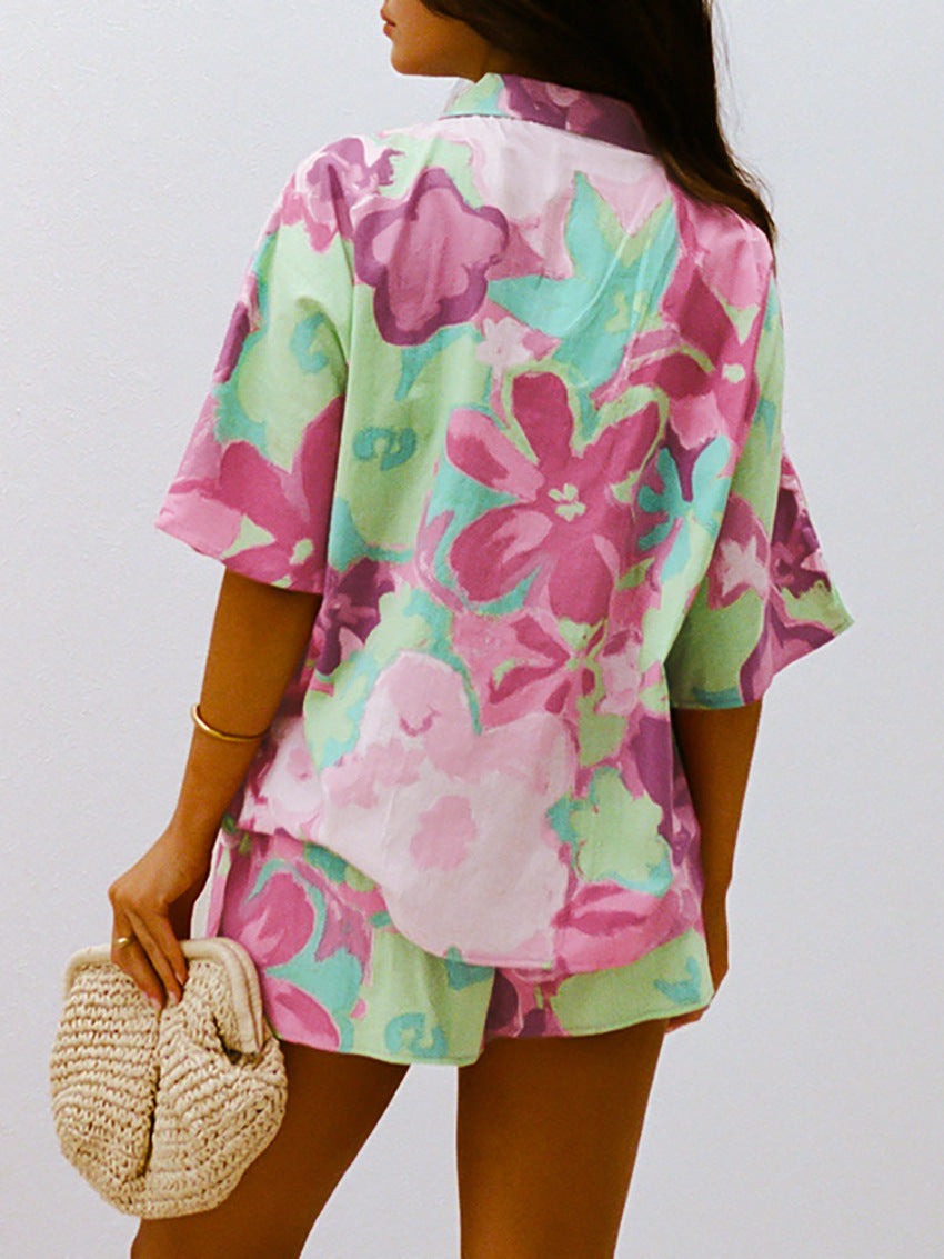 Frau in bunter, floraler Sommerkleidung, hält eine gehäkelte Tasche. Modetrend 2023, lässiger Stil, lebendige Farben, florales Design.
