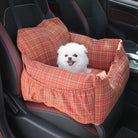 Kleiner weißer Hund in rotem kariertem Autositz für Haustiere, sicherer Transport, bequem.