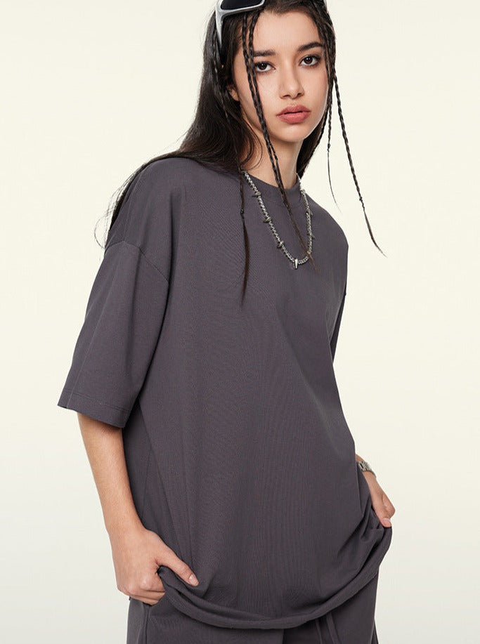 Dunkelgraues Oversize-T-Shirt für Damen, lässiger Streetwear-Look, ideal für trendige Outfits. Perfekt kombinierbar mit urbaner Mode.