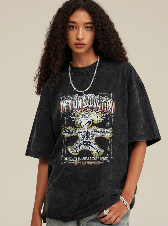 Schwarzes Oversize-T-Shirt mit auffälligem Cartoon-Print und Schriftzug, getragen von einer Frau. Trendige Streetwear, ideal für lässige Outfits.