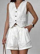Damen Sommeranzug in Weiß, ärmellose Weste mit Knöpfen und Shorts. Perfekt für elegante Freizeitmode und stilvolle Sommeroutfits.