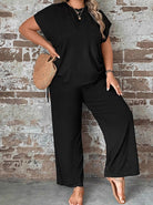Damen-Outfit in Schwarz, bestehend aus lockerem T-Shirt und weiten Hosen, kombiniert mit Strohtasche. Perfekt für lässige Sommermode.