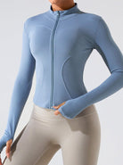 Damen-Sportjacke in Hellblau, figurbetont, mit Reißverschluss und Daumenlöchern. Ideal für Fitness, Yoga und Outdoor-Aktivitäten.